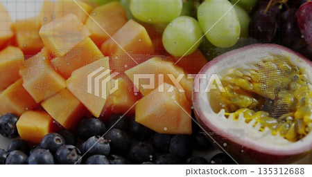 Displaying papaya cubes, grapes, blueberries, halved passion fruit on studio table with map overlay Displaying papaya cubes, grapes, blueberries, halved passion fruit on studio table with map overlay 135312688