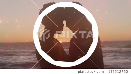 Pressing foreheads couple standing on beach at sunset, with white octagonal frame, water horizon Pressing foreheads couple standing on beach at sunset, with white octagonal frame, water horizon 135312760