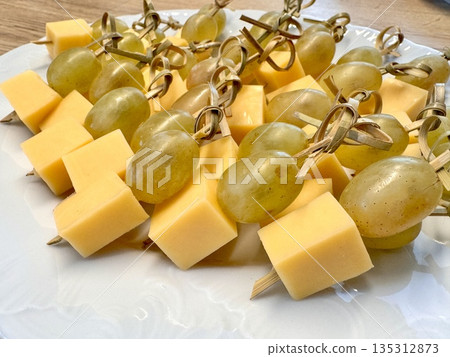 New Year's snack skewers hard cheese with grapes on the festive table 135312873