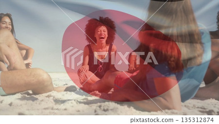 Laughing curly woman sitting with friends on white sand at beach, wearing swimsuit and sunglasses Laughing curly woman sitting with friends on white sand at beach, wearing swimsuit and sunglasses 135312874