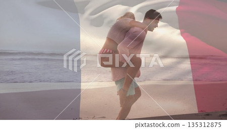Piggybacking couple in swimwear walking along wet sand at beach edge, with French flag overlay Piggybacking couple in swimwear walking along wet sand at beach edge, with French flag overlay 135312875