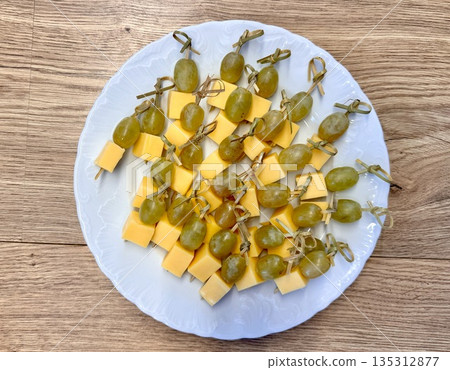 New Year's snack skewers hard cheese with grapes on the festive table 135312877