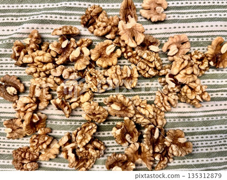 A washed, peeled walnut is lying on a cotton kitchen towel A washed, peeled walnut is lying on a cotton kitchen towel 135312879
