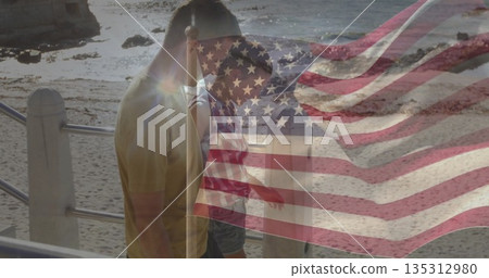Walking couple gazing rocky shore from railing at waterfront walkway, with American flag overlay 135312980