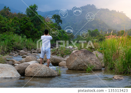 Young man hand using smartphone with to Interconnect, Interconnected Concept; People connect via wireless internet in a world of digital technology and communications that connect Young man hand using smartphone with to Interconnect, Interconnected Concept; People connect via wireless internet in a world of digital technology and communications that connect 135313423