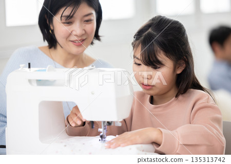 An elementary school girl sewing with her mother 135313742