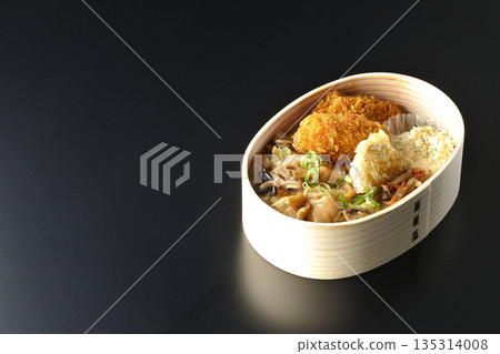 Mushroom rice and fried oyster bento photographed against a black background 135314008