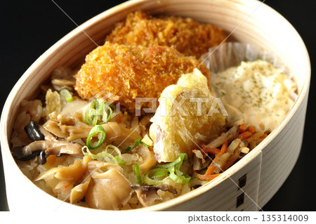 Mushroom rice and fried oyster bento photographed against a black background Mushroom rice and fried oyster bento photographed against a black background 135314009
