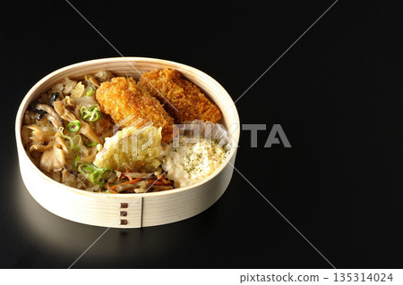 Mushroom rice and fried oyster bento photographed against a black background 135314024
