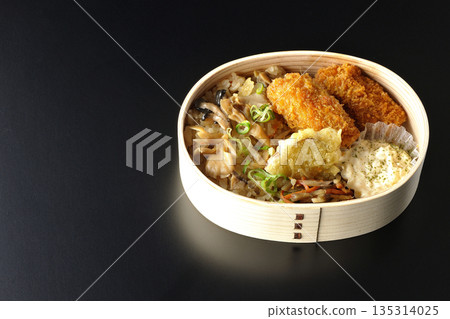 Mushroom rice and fried oyster bento photographed against a black background 135314025