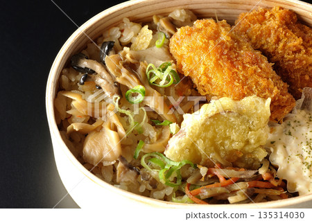 蘑菇飯和炸蠔便當,以黑色背景拍攝 蘑菇飯和炸蠔便當,以黑色背景拍攝 135314030