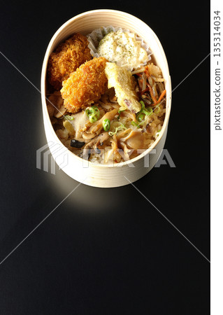 Mushroom rice and fried oyster bento photographed against a black background 135314034