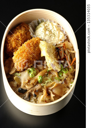 Mushroom rice and fried oyster bento photographed against a black background 135314035