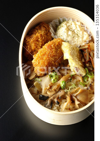 Mushroom rice and fried oyster bento photographed against a black background 135314036