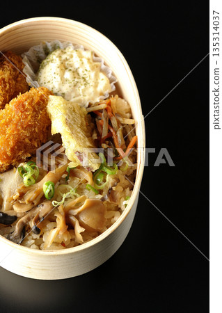 Mushroom rice and fried oyster bento photographed against a black background 135314037