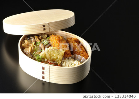 Mushroom rice and fried oyster bento photographed against a black background Mushroom rice and fried oyster bento photographed against a black background 135314040