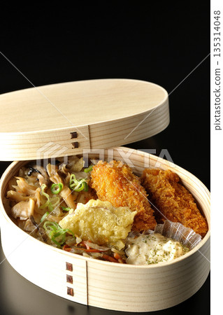 Mushroom rice and fried oyster bento photographed against a black background 135314048