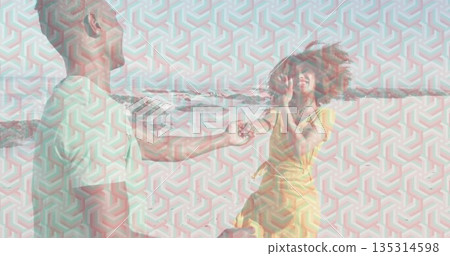 Kneeling man offering small jewelry box to woman in yellow sundress on sandy beach, proposal 135314598