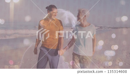 Walking middle-aged man and senior woman holding hands on sandy shore, with waves and pastel bokeh Walking middle-aged man and senior woman holding hands on sandy shore, with waves and pastel bokeh 135314608
