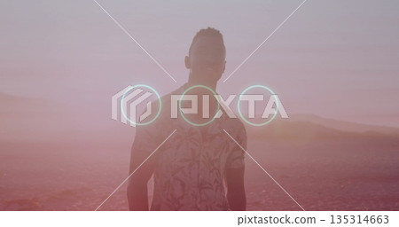 Standing male wearing floral shirt gazing across salt flat at sunset, with three glowing cyan rings Standing male wearing floral shirt gazing across salt flat at sunset, with three glowing cyan rings 135314663