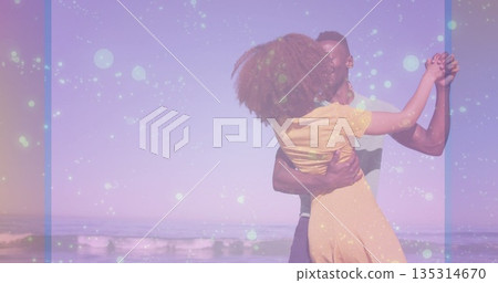 Dancing couple wearing yellow dress and short sleeved shirt spinning at beach shore, pastel filter Dancing couple wearing yellow dress and short sleeved shirt spinning at beach shore, pastel filter 135314670
