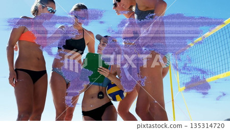 Gathering team wearing bikinis at beach court, with green clipboard stopwatch net yellow-blue ball 135314720