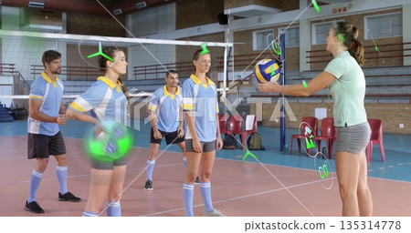 Holding colorful volleyball coach guiding team practicing net drills in gym, with boundary lines Holding colorful volleyball coach guiding team practicing net drills in gym, with boundary lines 135314778