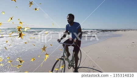 Riding man in blue shirt, maroon shorts pedaling wet sand at beach, green bicycle, golden stars Riding man in blue shirt, maroon shorts pedaling wet sand at beach, green bicycle, golden stars 135314810