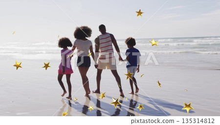 Strolling family of four along wet shoreline at low tide on beach, with golden star overlays Strolling family of four along wet shoreline at low tide on beach, with golden star overlays 135314812