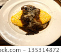 Omelette with demi-glace sauce on a white plate 135314872