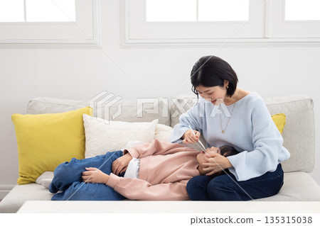 Mother brushing her daughter's teeth Mother brushing her daughter's teeth 135315038