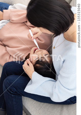 一位小學生正被她的母親刷牙。 135315040