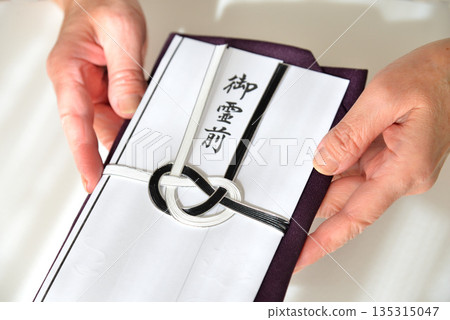 Image of handing over a condolence envelope 135315047