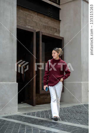 Full body shot of pretty asian woman in red sweater standing and posing in shopping mall or market. 135315163