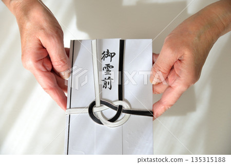 Image of handing over a condolence envelope 135315188
