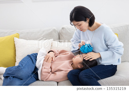 母親正在幫女兒額頭敷冰袋 135315219