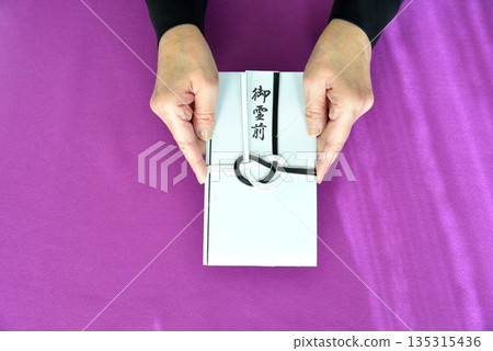 Image of handing over a condolence envelope 135315436