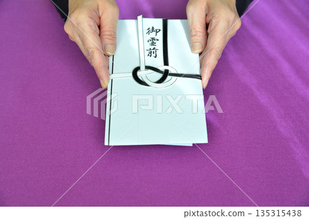 Image of handing over a condolence envelope 135315438