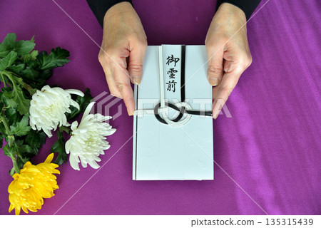 Image of handing over a condolence envelope 135315439