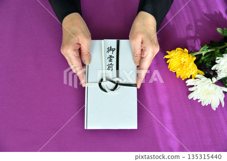 Image of handing over a condolence envelope 135315440