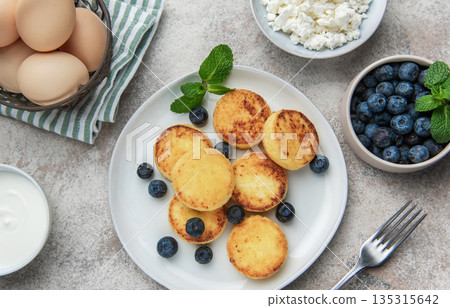 Syrniki cottage cheese pancakes with fresh blueberries and mint breakfast Syrniki cottage cheese pancakes with fresh blueberries and mint breakfast 135315642