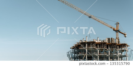 Construction of a building banner background. Construction site with crane. Business, development, industry. 135315790