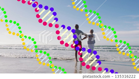 Spinning mature couple in casual beach attire holding hands on wet sand, with ocean waves Spinning mature couple in casual beach attire holding hands on wet sand, with ocean waves 135316222