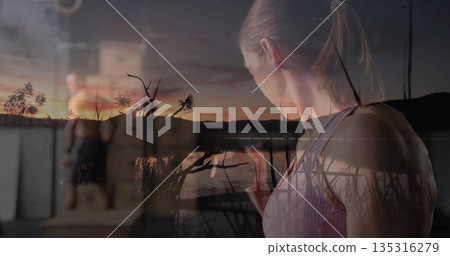 Lifting dumbbell, female exerciser training inside gym area, with lakeside sunset overlay and reeds Lifting dumbbell, female exerciser training inside gym area, with lakeside sunset overlay and reeds 135316279