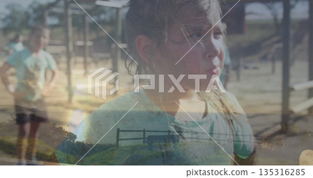 Girl catching breath in green tee at playground with metal frame bars, woodchip ground, copy space 135316285