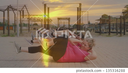 Performing bicycle crunches six women in sportswear exercising at fitness park, with metal frames 135316288