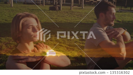 Stretching friends in sportswear performing chest stretch on yoga mats at park, with fitness watch 135316302