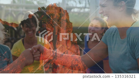 Cheering team members wearing sportswear sharing fist bump at gym with bars, red cliff overlay 135316321