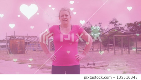 Pausing fit woman in pink top black leggings catching breath at obstacle course, with wooden frames Pausing fit woman in pink top black leggings catching breath at obstacle course, with wooden frames 135316345