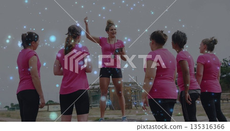Leading fitness instructor on platform directing trainees on dusty field with tablet timer whistle Leading fitness instructor on platform directing trainees on dusty field with tablet timer whistle 135316366